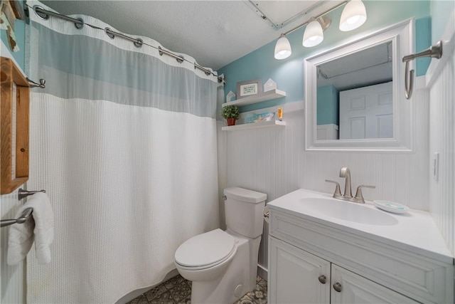 full bath with curtained shower, vanity, toilet, and a textured ceiling