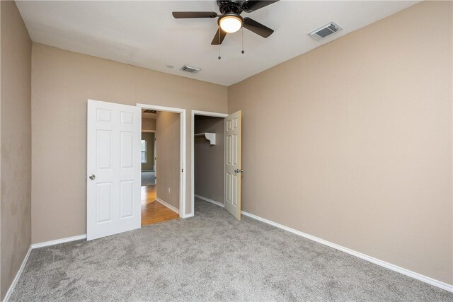 unfurnished bedroom with ceiling fan and light colored carpet