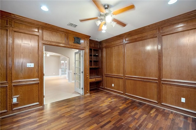 unfurnished room with ceiling fan and dark wood-type flooring