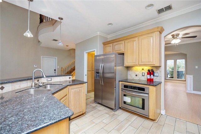 kitchen featuring sink, hanging light fixtures, ceiling fan, light brown cabinetry, and stainless steel appliances