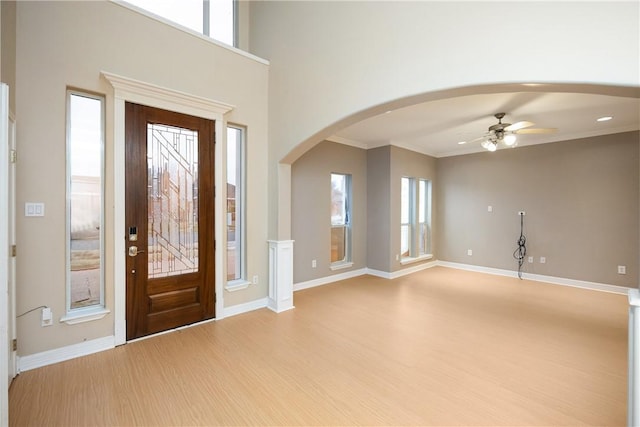 entrance foyer featuring light hardwood / wood-style flooring, ceiling fan, and crown molding