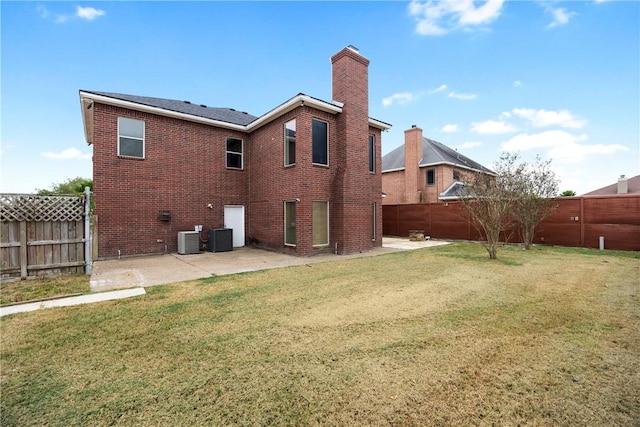 rear view of property featuring cooling unit, a patio area, and a yard