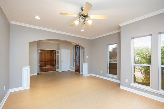 empty room with ceiling fan, light wood-type flooring, and ornamental molding