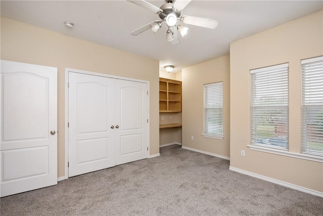 unfurnished bedroom with ceiling fan and light colored carpet