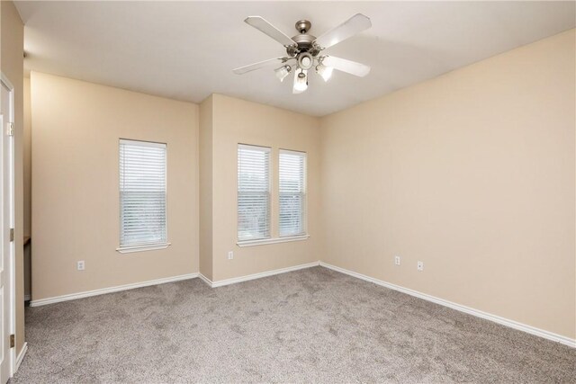 carpeted spare room featuring ceiling fan