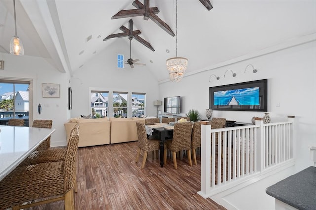 dining area featuring hardwood / wood-style flooring, ceiling fan with notable chandelier, high vaulted ceiling, and beamed ceiling