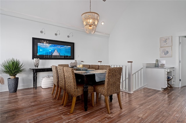 dining space with dark wood-type flooring, lofted ceiling, and a chandelier