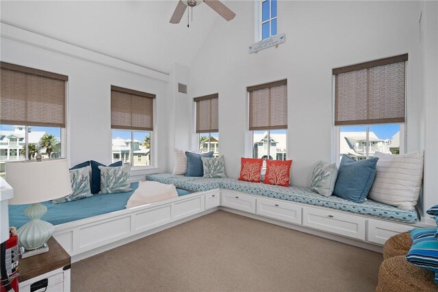 interior space featuring a towering ceiling, carpet floors, and ceiling fan