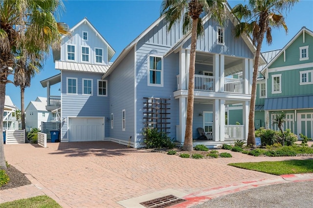 beach home featuring a garage, a balcony, and a porch