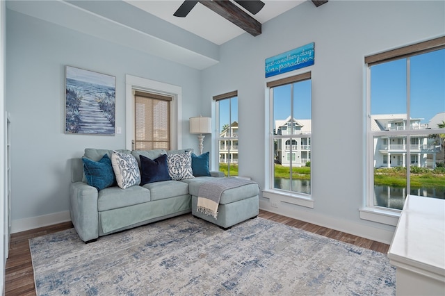 living room with hardwood / wood-style floors, beam ceiling, ceiling fan, and a water view