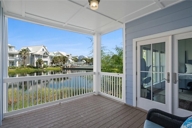 deck with a water view and french doors