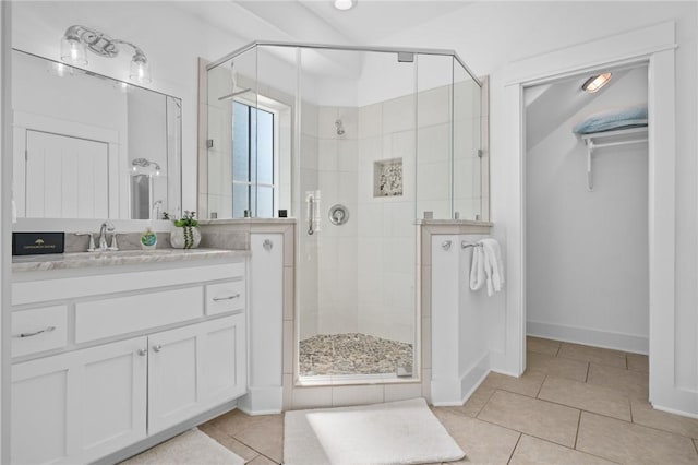 bathroom with tile patterned flooring, vanity, and an enclosed shower