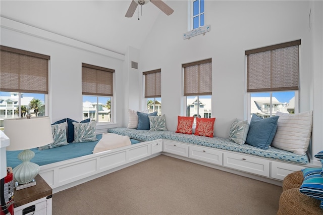 sitting room featuring ceiling fan, high vaulted ceiling, and carpet