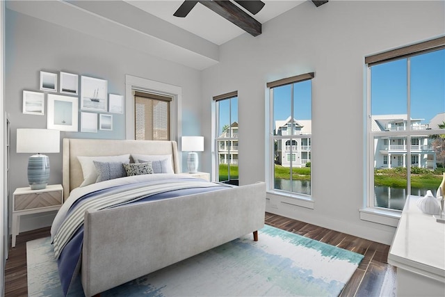 bedroom with beamed ceiling, ceiling fan, dark hardwood / wood-style floors, and a water view