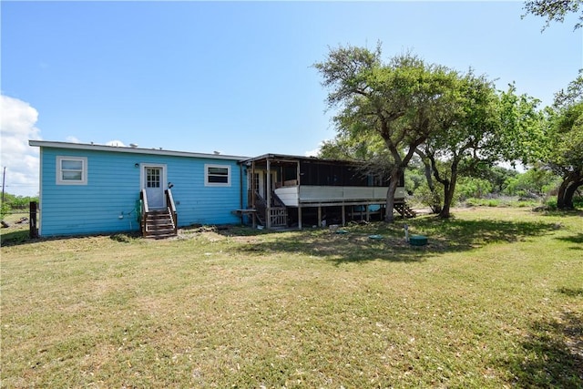 back of property with a yard, entry steps, and a sunroom