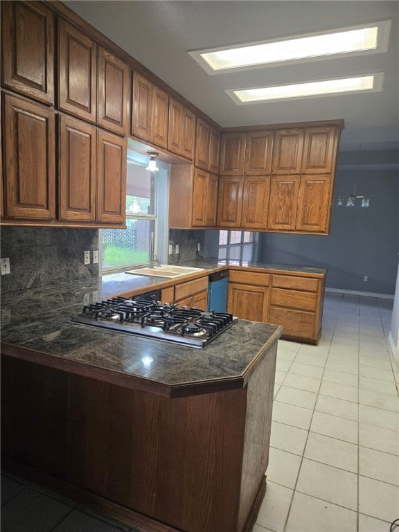 7921 Etienne Dr, Corpus Christi, TX 78414 - kitchen featuring stainless steel gas stovetop, a peninsula, light tile patterned floors, and decorative backsplash
