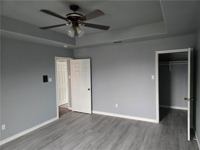7921 Etienne Dr, Corpus Christi, TX 78414 - unfurnished bedroom with wood finished floors, a spacious closet, and a raised ceiling
