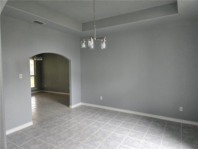 7921 Etienne Dr, Corpus Christi, TX 78414 - empty room with a tray ceiling, arched walkways, tile patterned flooring, and a chandelier