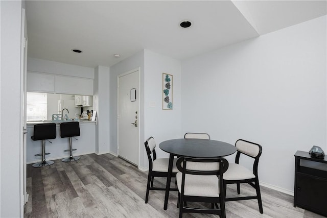 dining room with light wood-style flooring and baseboards