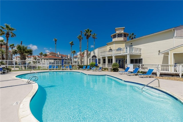community pool with fence and a patio