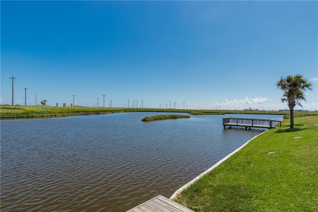 dock area with a water view and a lawn