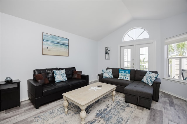 living room featuring french doors, wood-type flooring, and lofted ceiling