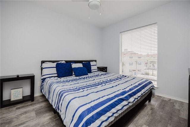 bedroom with wood finished floors, baseboards, and a ceiling fan