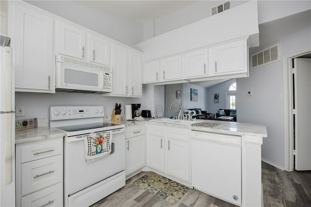 kitchen with white appliances, a sink, a peninsula, light wood-type flooring, and white cabinets