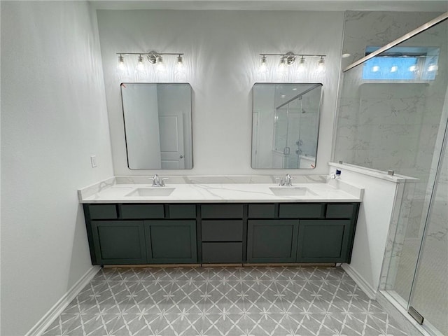 bathroom with baseboards, a sink, a marble finish shower, and double vanity