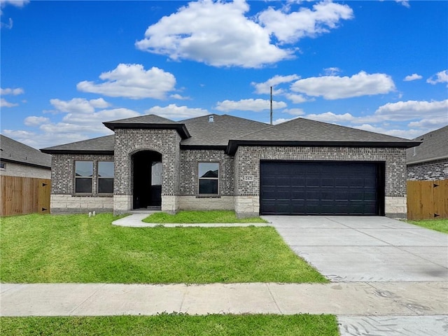 view of front of house with brick siding, concrete driveway, fence, a garage, and a front lawn