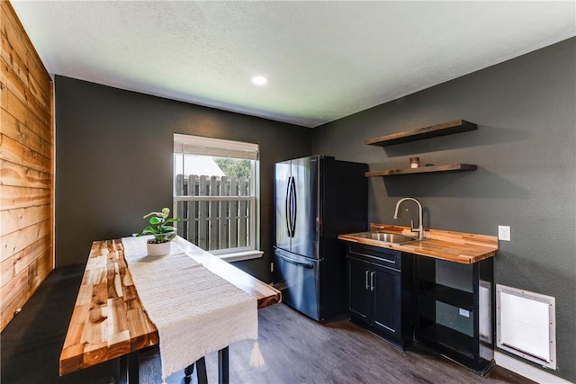 502 Corpus Christi Channel Prt, Aransas, TX 78373 - kitchen with freestanding refrigerator, butcher block countertops, dark cabinetry, wood walls, and dark wood finished floors