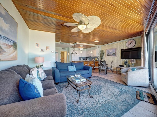 living area with ceiling fan, light tile patterned flooring, and wooden ceiling