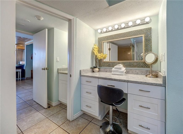 bathroom with baseboards, a textured ceiling, vanity, and tile patterned flooring