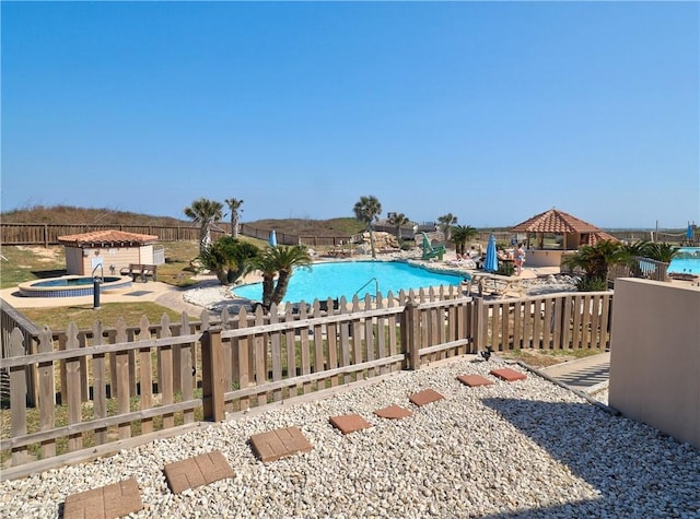 pool with fence private yard and a hot tub