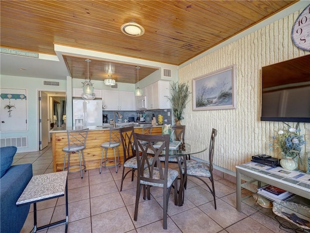 dining room featuring light tile patterned floors, visible vents, and wooden ceiling