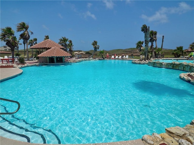 community pool with a gazebo and fence