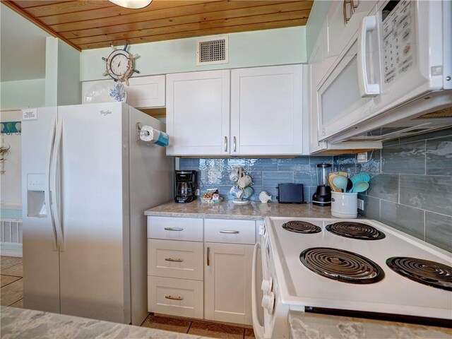 kitchen with visible vents, backsplash, light tile patterned flooring, white cabinets, and white appliances