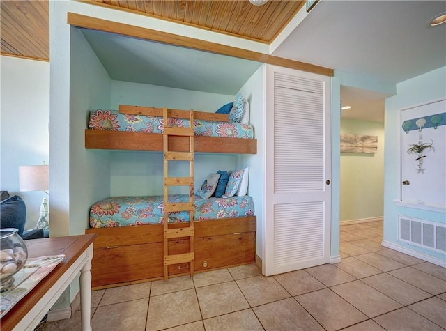 tiled bedroom with visible vents, baseboards, and a closet