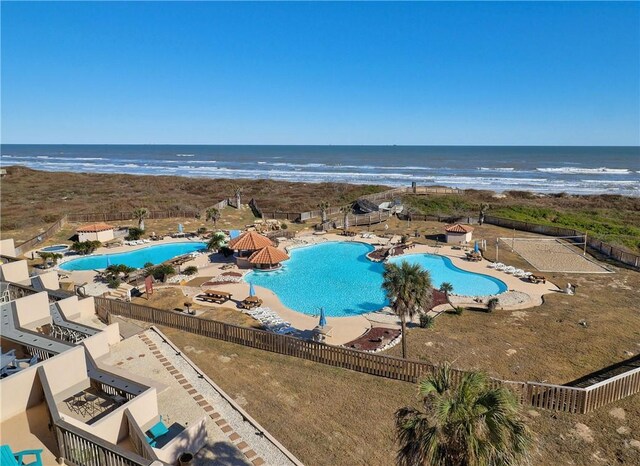 pool featuring fence, a patio, and a water view