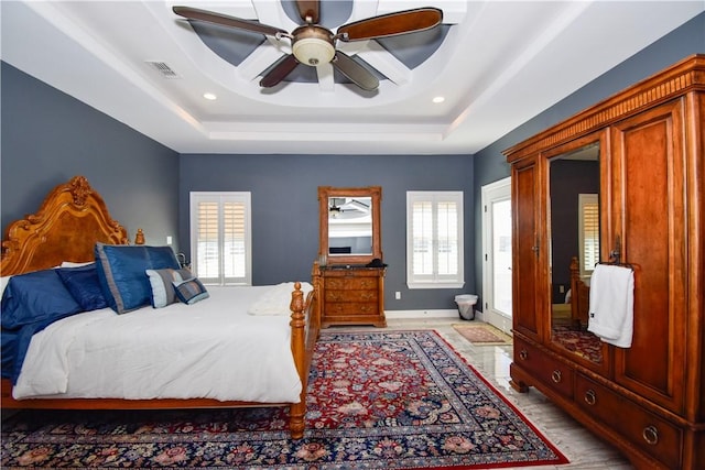 bedroom with a tray ceiling and ceiling fan