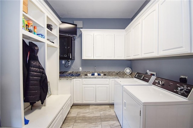 laundry area featuring cabinets, washing machine and dryer, and sink