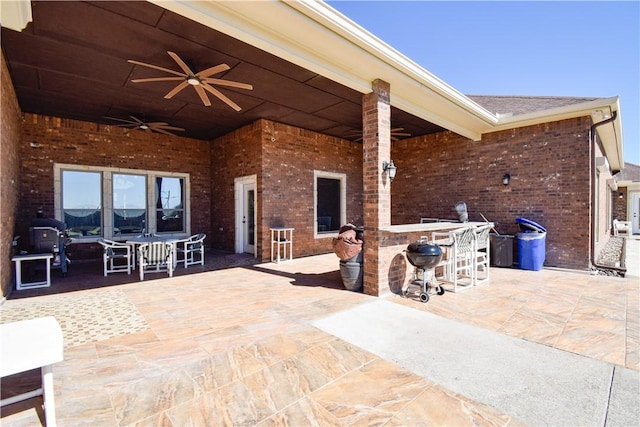 view of patio / terrace with ceiling fan and a bar