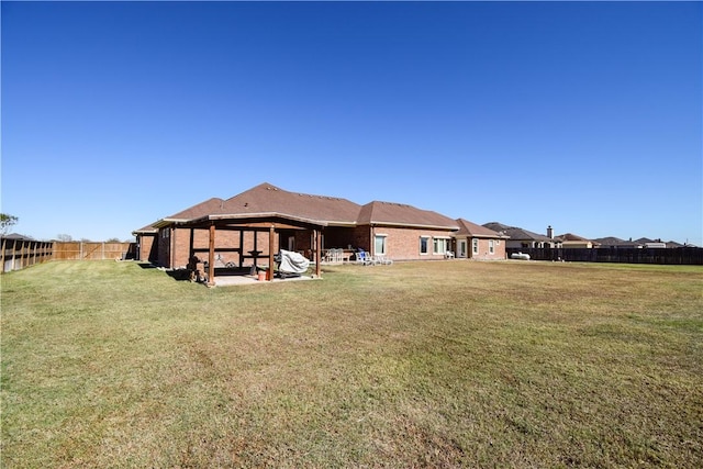 rear view of house with a yard and a patio