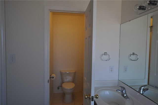 half bathroom featuring toilet, tile patterned flooring, and a sink