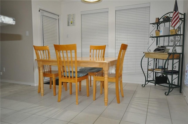 dining space featuring baseboards and light tile patterned flooring