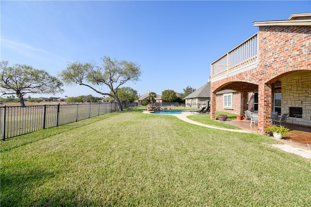 view of yard with a patio, a fenced in pool, and a balcony