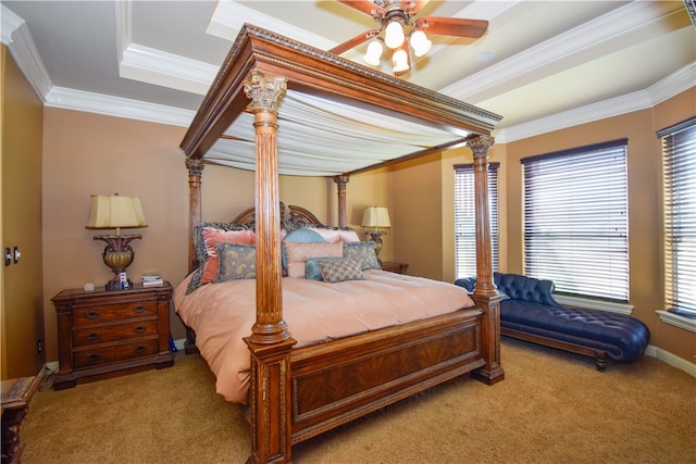 carpeted bedroom with a tray ceiling, ceiling fan, and ornamental molding