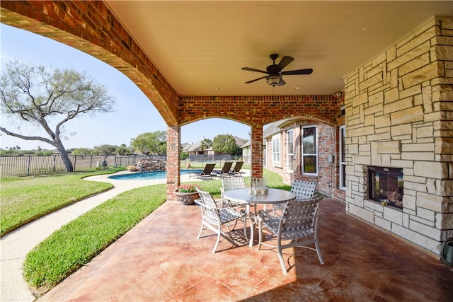 view of patio featuring a fenced in pool and ceiling fan