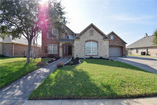 view of front of property with a front lawn, central AC unit, and a garage