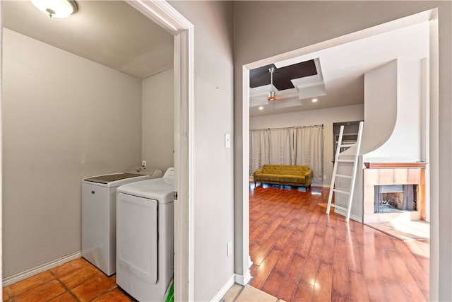 laundry area featuring hardwood / wood-style floors, washing machine and dryer, and a large fireplace